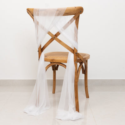 White sheer chair sashes elegantly draping a wooden cross-back chair.