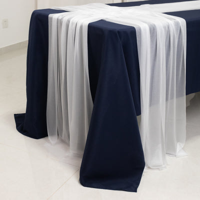 Navy tablecloth with sheer white overlay draped elegantly on a table.
