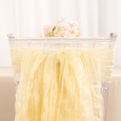 Yellow organza chair sash draped elegantly on a clear chiavari chair.