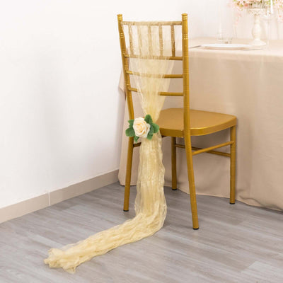 Gold chiavari chair with flowing yellow sash and flower decoration.