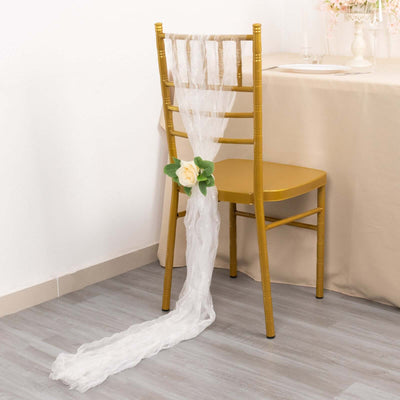White chair sash with rose accent on a gold chair in a decorated setting.