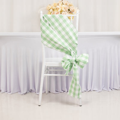 Green and white checked chair sash tied in a bow on a white chair.