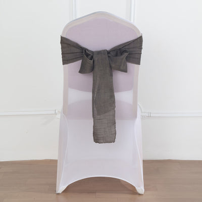 Transparent chair with a dark gray fabric bow on a plain backdrop
