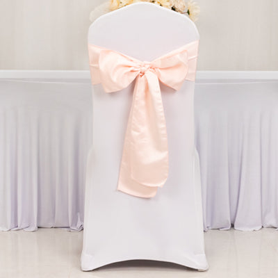 White chair cover with a soft pink satin bow tied at the back.