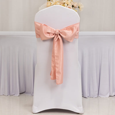 White chair cover with a peach satin bow tied at the back.