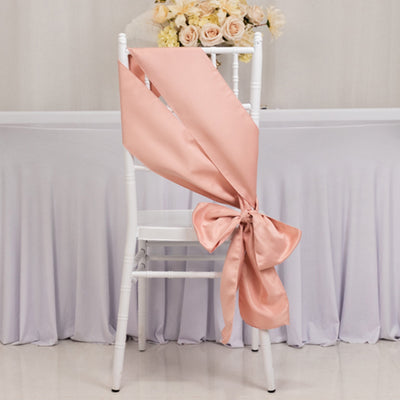 Peach satin chair sash tied in a bow on a white chair