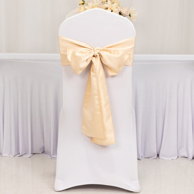 Cream satin chair cover with a bow, perfect for weddings and events.