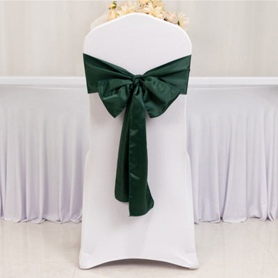 White chair cover with a green satin bow