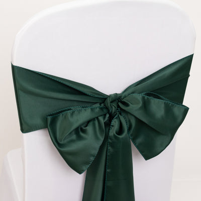 Green satin chair bow tied elegantly on a white chair.