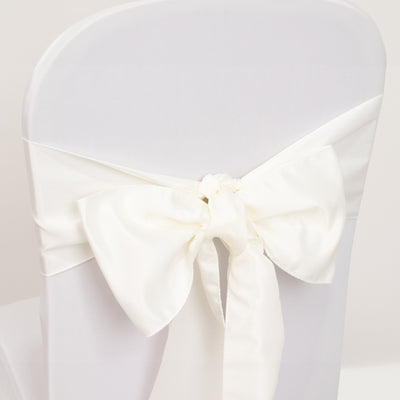 White satin chair cover bow on a plain chair.