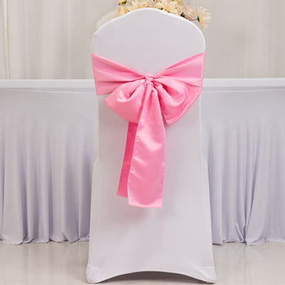 White chair cover with a pink satin bow tied at the back.