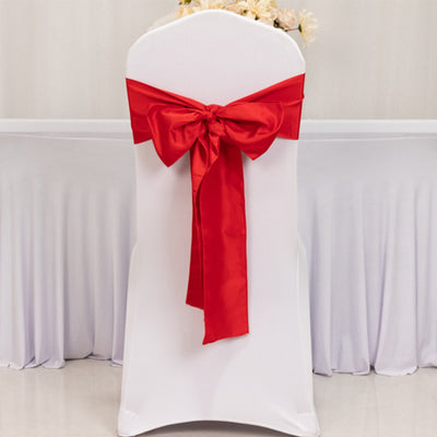 White chair cover with a red bow tie, ideal for events and weddings.