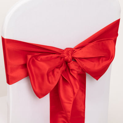 Red satin chair sash with bow detail for event decoration.