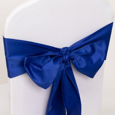 Royal blue satin chair ribbon bow on a white chair.