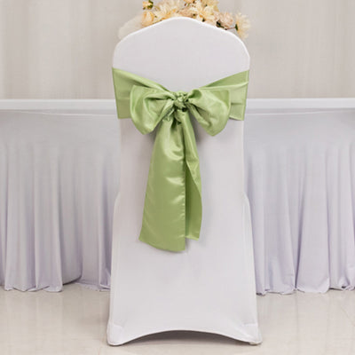 White chair cover with a green satin bow, ideal for events and weddings.