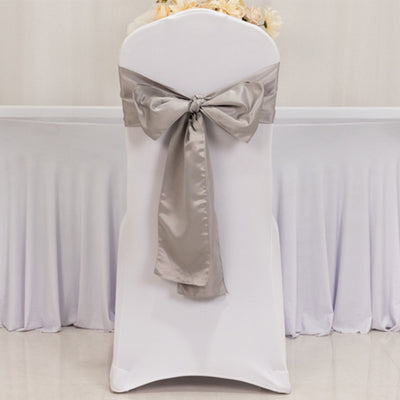 White chair cover with a silver satin bow, perfect for events and weddings.