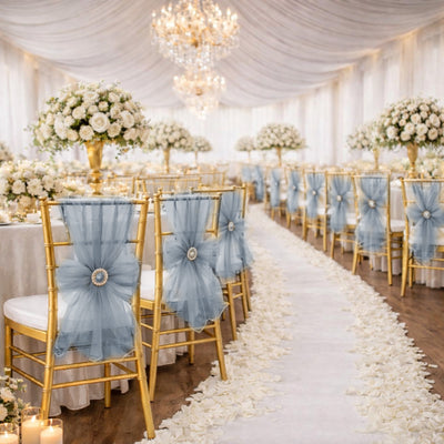 Elegant white and gold wedding reception with blue tulle chairs and floral aisle