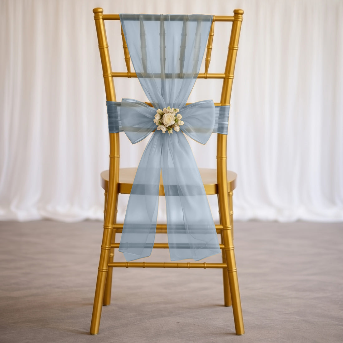 Gold chiavari chair with light blue sheer bow and floral centerpiece