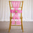 Gold chiavari chair with pink sheer bow and floral centerpiece around 100 chars