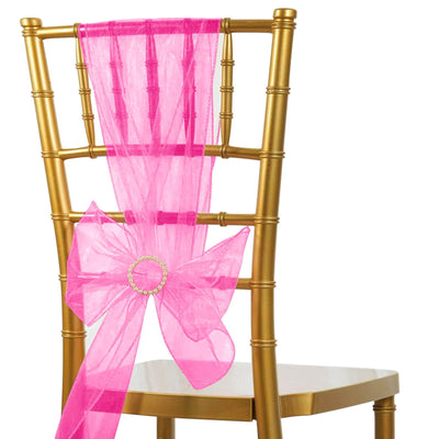 Pink organza chair sash with a bow on a gold chiavari chair