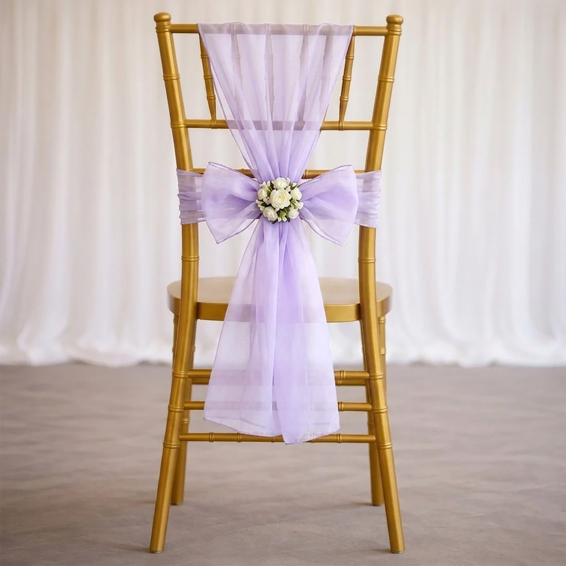 Gold chiavari chair with lavender sheer bow and floral wedding decor