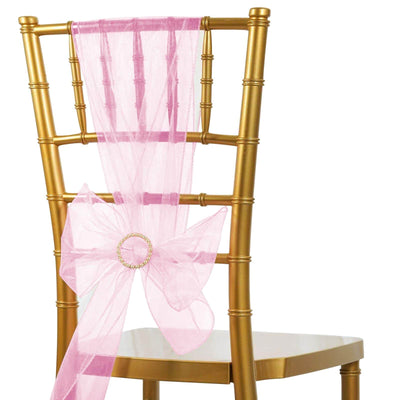 Pink organza chair sash with bow on a gold Chiavari chair.