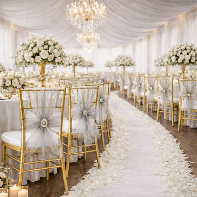 Elegant wedding reception setup with floral arrangements and decorated chairs.