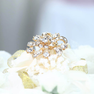 Gold and rhinestone brooch on a floral arrangement.