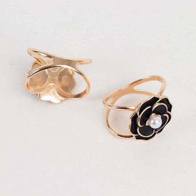 Gold and black flower ring with pearl detail, studio shot