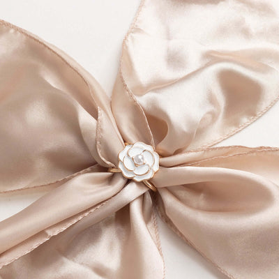 Elegant beige satin ribbon with a floral pin detail.
