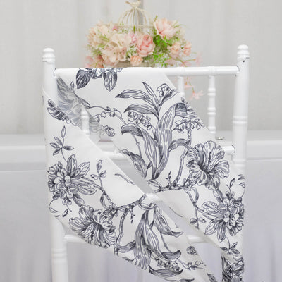 Floral patterned fabric draped over a white chair in a styled setting.