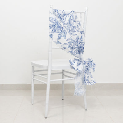 White chair with blue floral fabric draped and tied at the back.