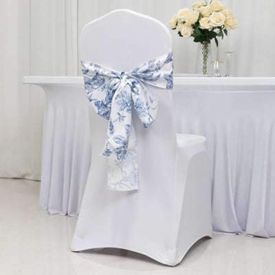 White chair cover with blue floral bow at an elegant event table.