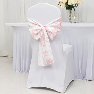 White chair cover with pink floral bow for event decoration.