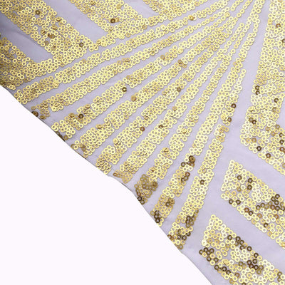 Gold sequin fabric with a radiant pattern on a light background.