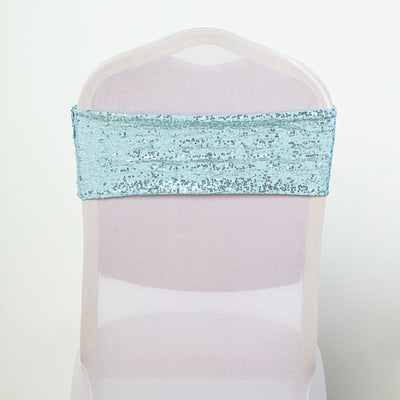 Blue sequin chair cover sash on a transparent chair.