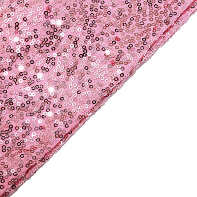 Pink sequin fabric with shimmering details on a white background.