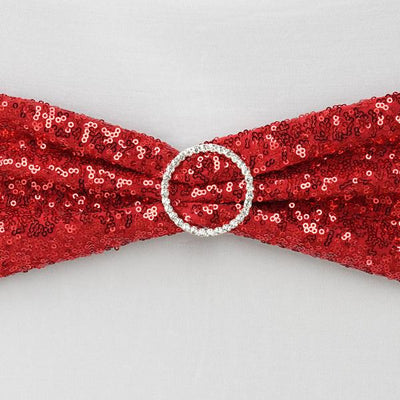 Red sequin bow with a rhinestone buckle on a plain background