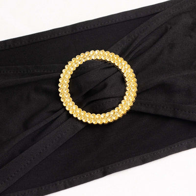Gold rhinestone circle belt buckle on black fabric.
