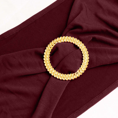 Gold beaded hair accessory on burgundy fabric.