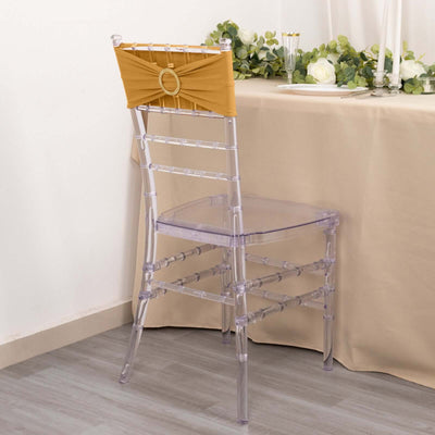 Clear chiavari chair with gold accent backrest against a neutral backdrop.