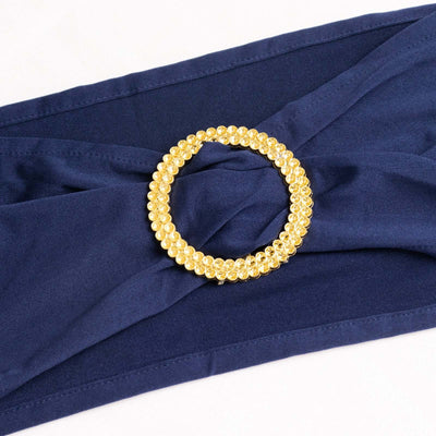 Navy blue fabric with a gold beaded circular brooch accent.