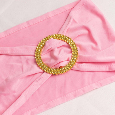 Pink fabric with a gold rhinestone ring accessory.