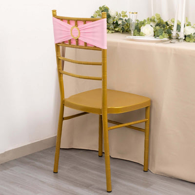 Gold chiavari chair with pink sash, set near a dining table.