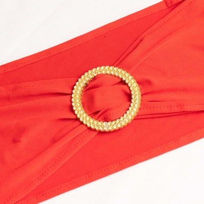 Red fabric belt with a jeweled gold circular buckle.