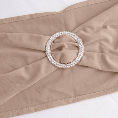 Beige fabric belt with a jeweled circular buckle.