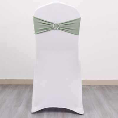 White chair cover with green sash and decorative ring detail.