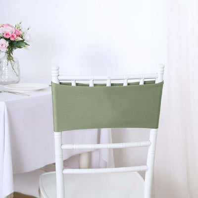 Green chair cover on a white wooden chair in a dining setting.