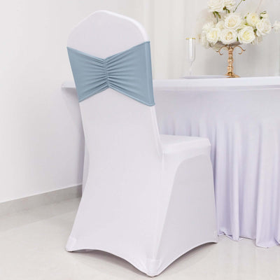 White chair cover with blue bow, styled for event decoration.