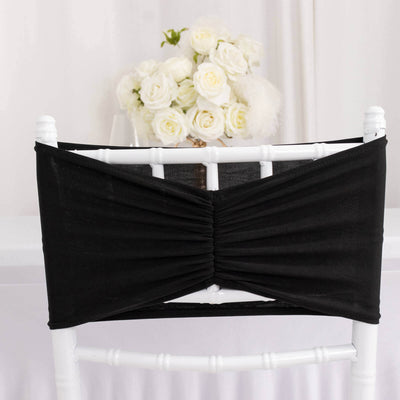 Black chair cover with ruched design on a white chair.